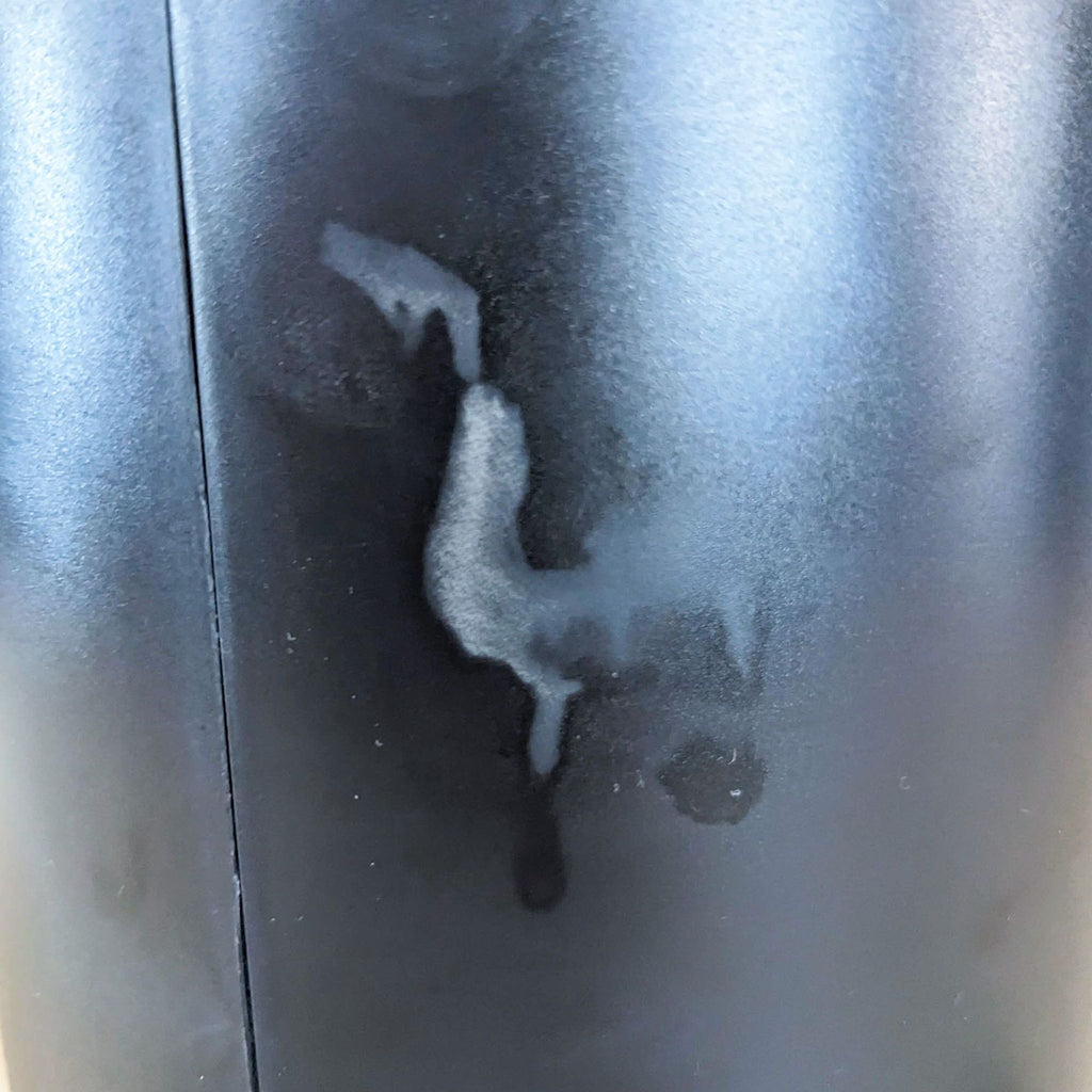 Close-up of marks on black Reperch device surface.