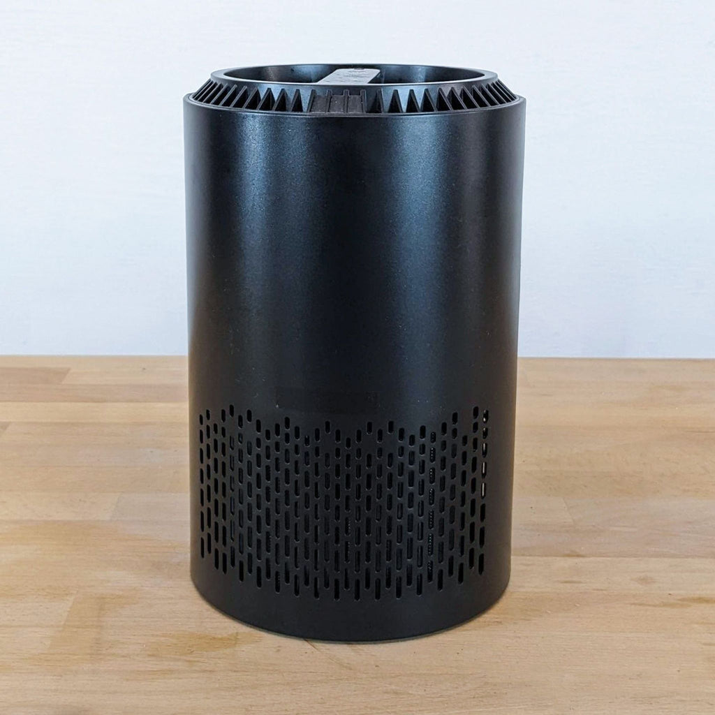 Black cylindrical device by Reperch on wooden table.