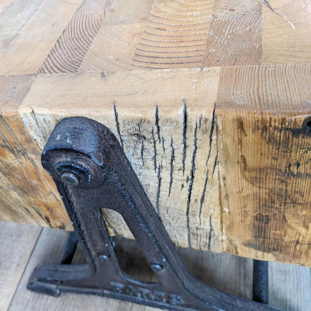Close-up of a rustic wooden coffee table's corner and detailed cast iron base.