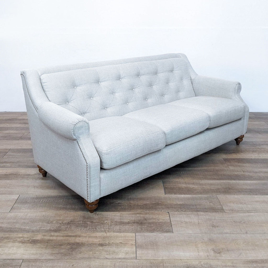 Angled view of a La-Z-Boy sofa featuring nail head detailing and elegant button tufting.