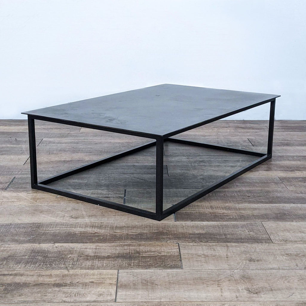 Industrial style coffee table with flat metal top and open base.