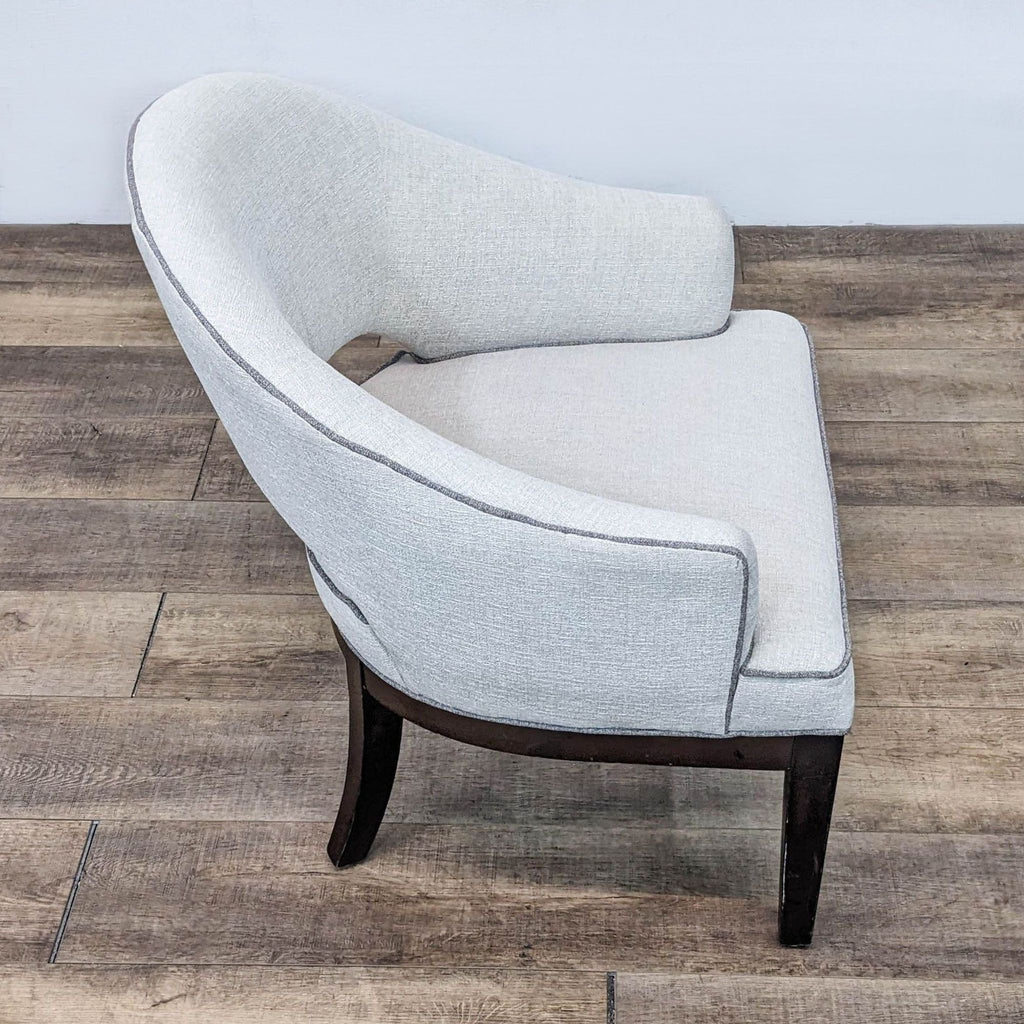 Angled view of the modern Crystal chair, highlighting its wide seat and contrasting trim by Madison Park.