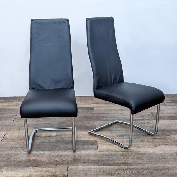 Two black Euro Style dining chairs with high backrests and chrome bases.  