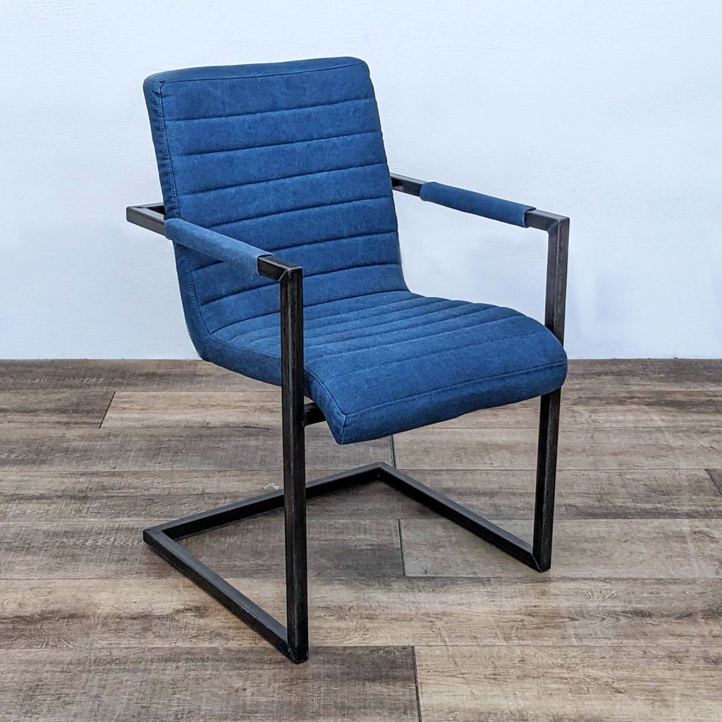 Single dining chair in blue fabric with channel tufting, featuring a modern metal frame.