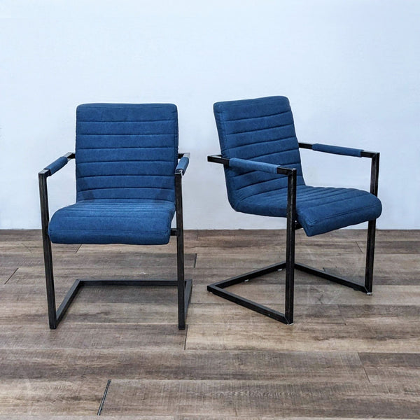 Pair of modern dining chairs with blue upholstery and metal frame. Channel tufting design.
