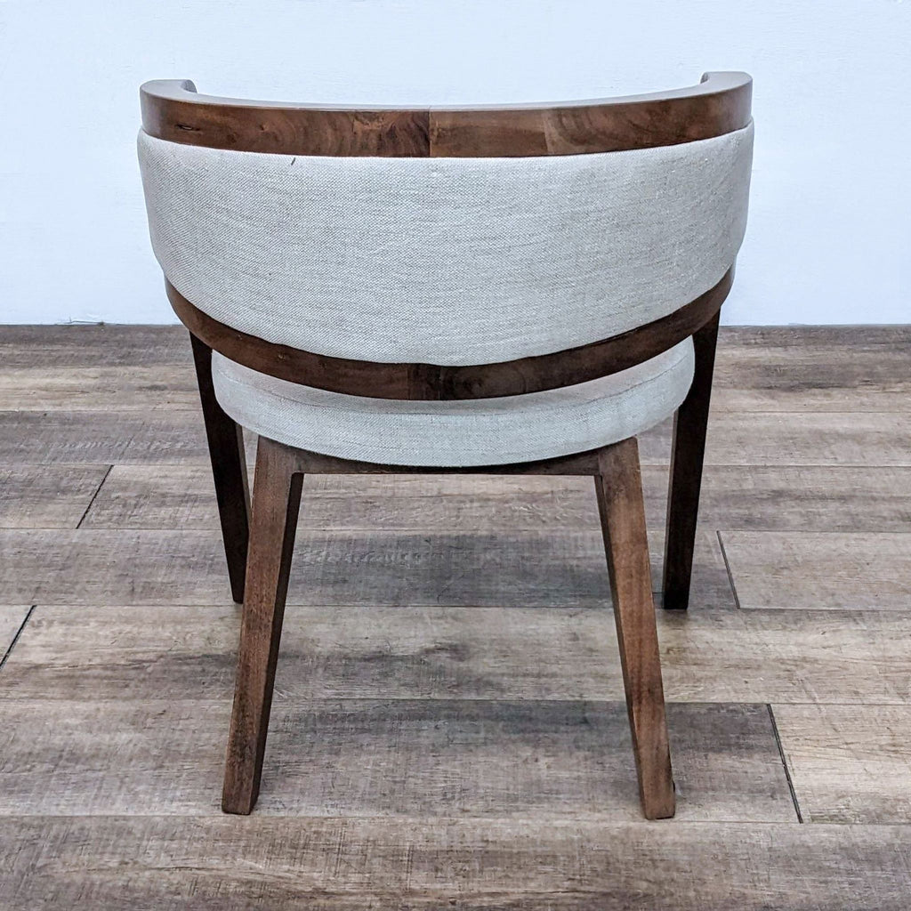 Back view of the Nesty accent chair showcasing the solid wood and curved design.