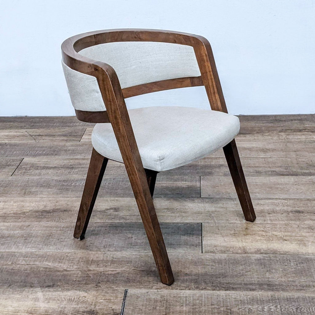 Side view of the Kathy Kuo accent chair featuring elegant curves and linen seating.
