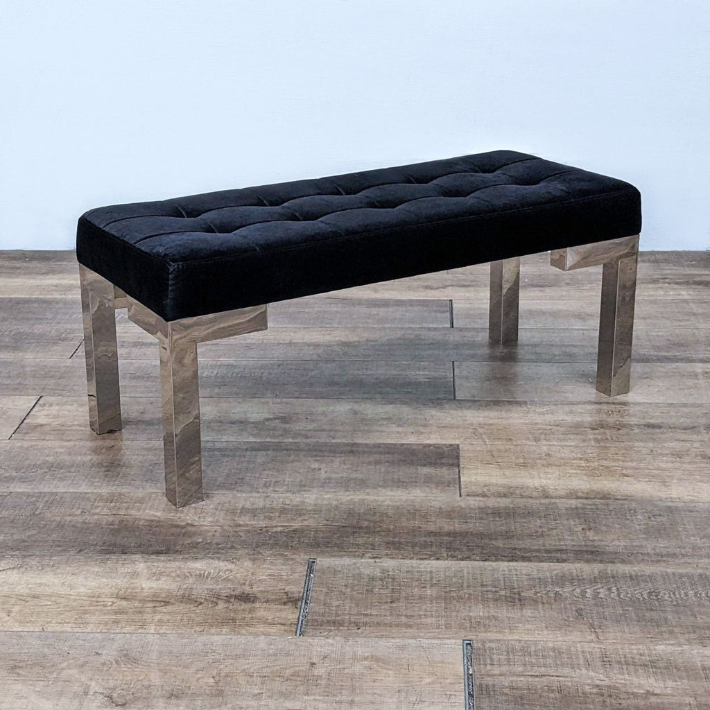 Elegant black velvet bench with tufting, supported by a sleek chrome frame.