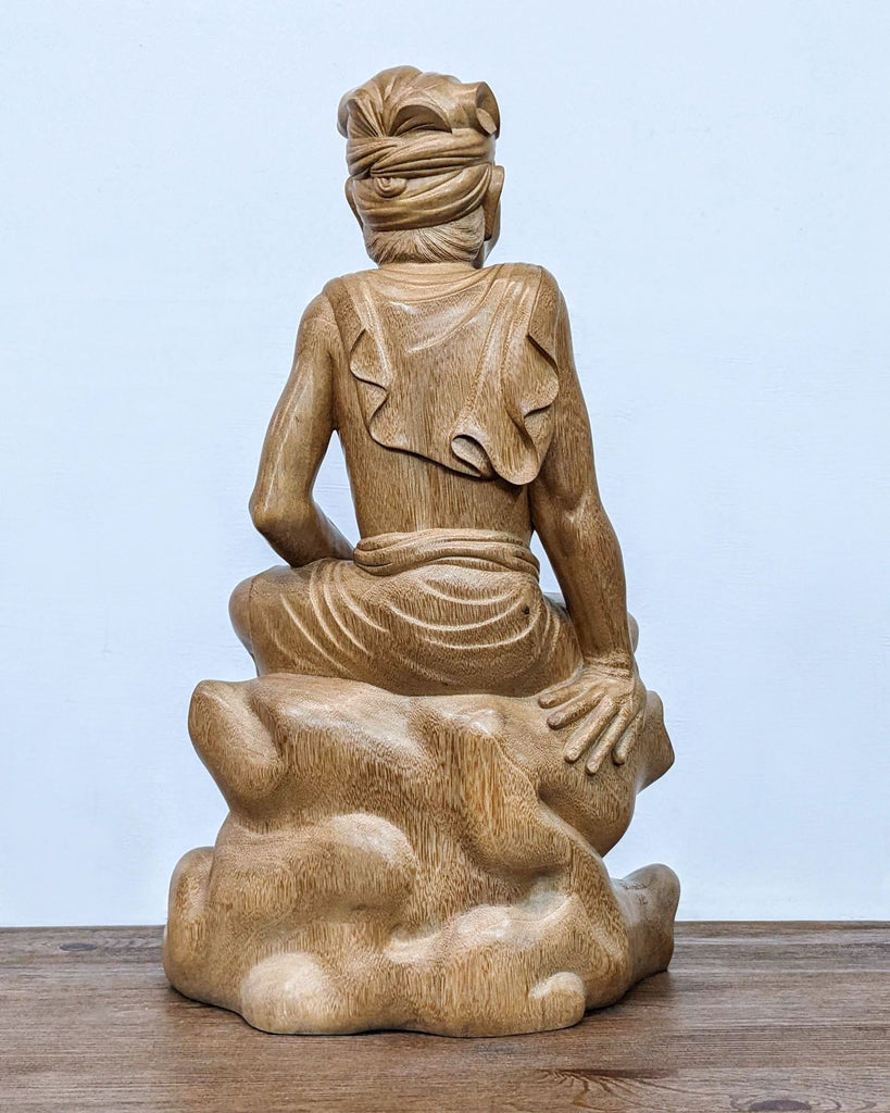 a statue of a man sitting on a table 