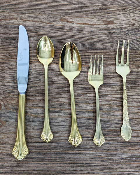Royal Sealy gold plated flatware set displayed on wood surface.