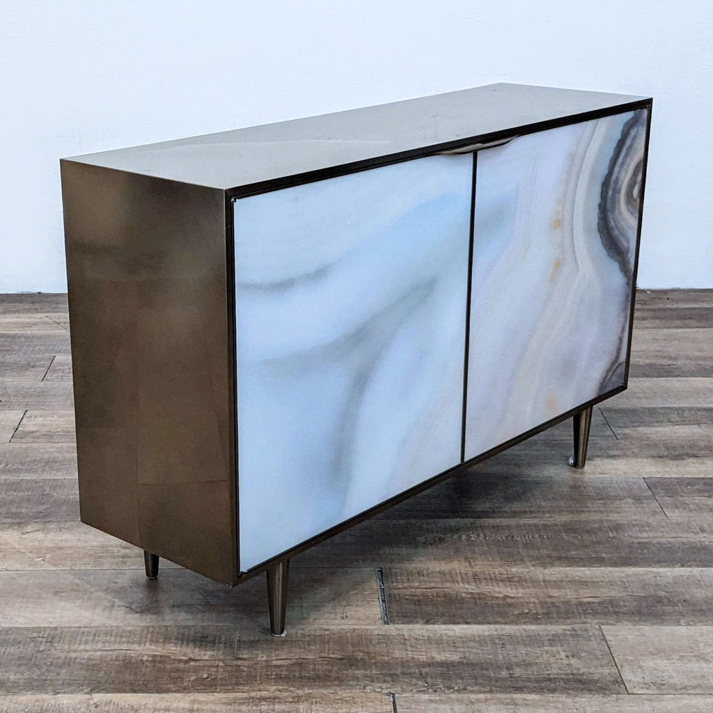 Angled view of Caracole cabinet highlighting agate pattern doors and conical feet.