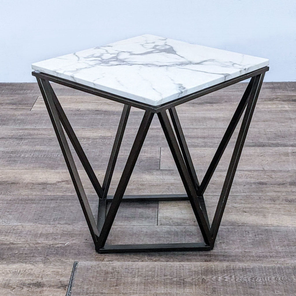 Square table with marble-like surface and angular frame.