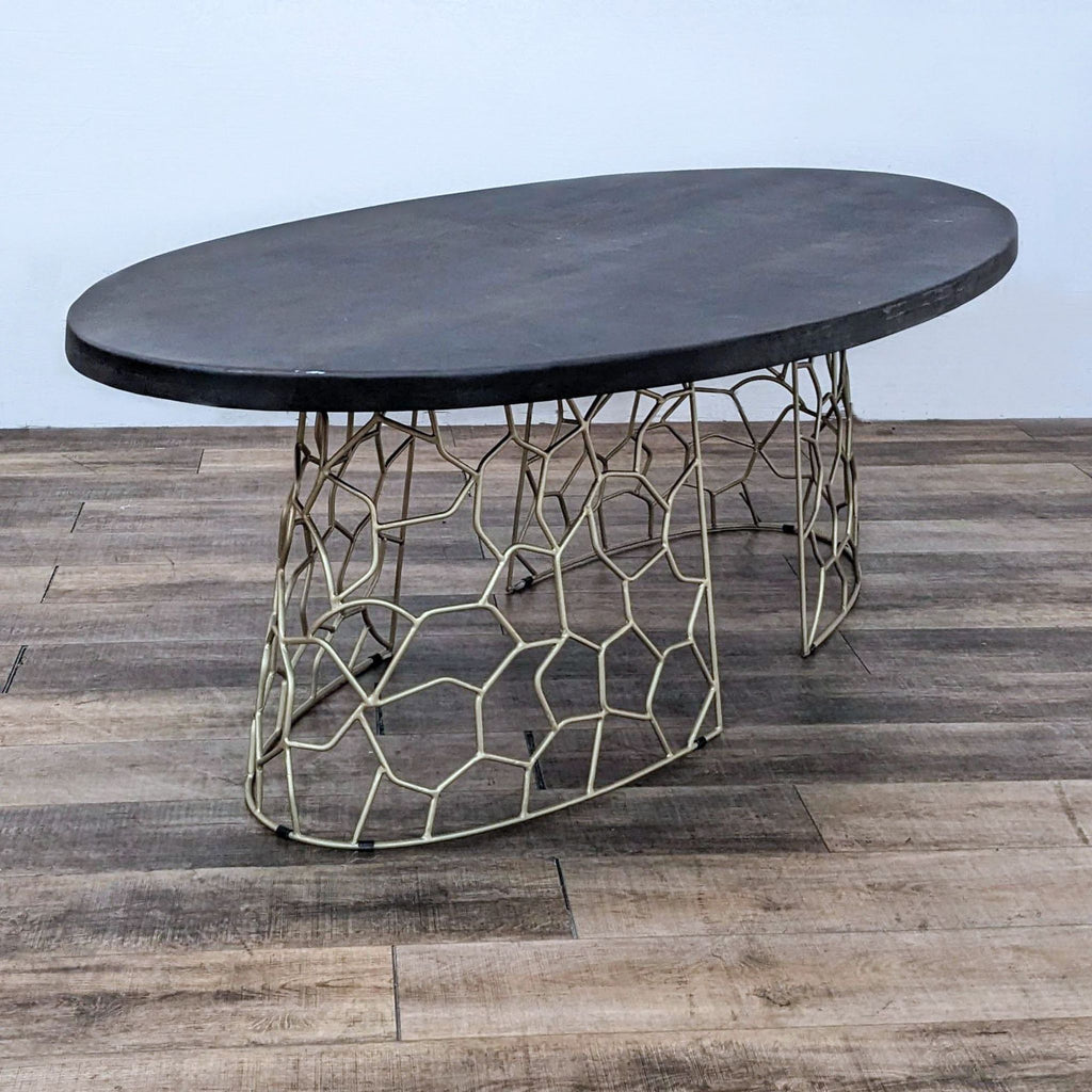 Dining table by Reperch with an oval top and unique gold base.
