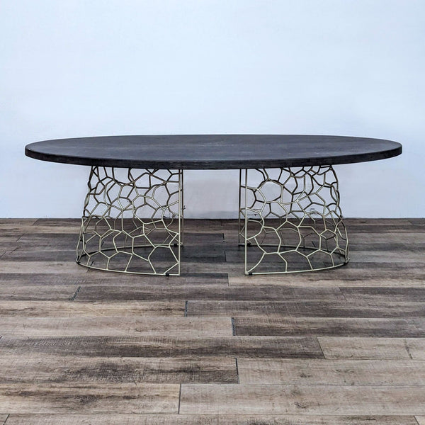 Contemporary oval dining table with a gold geometric base.