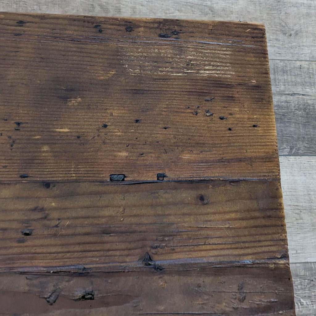 Detailed view of the Reperch coffee table's distressed wood surface.