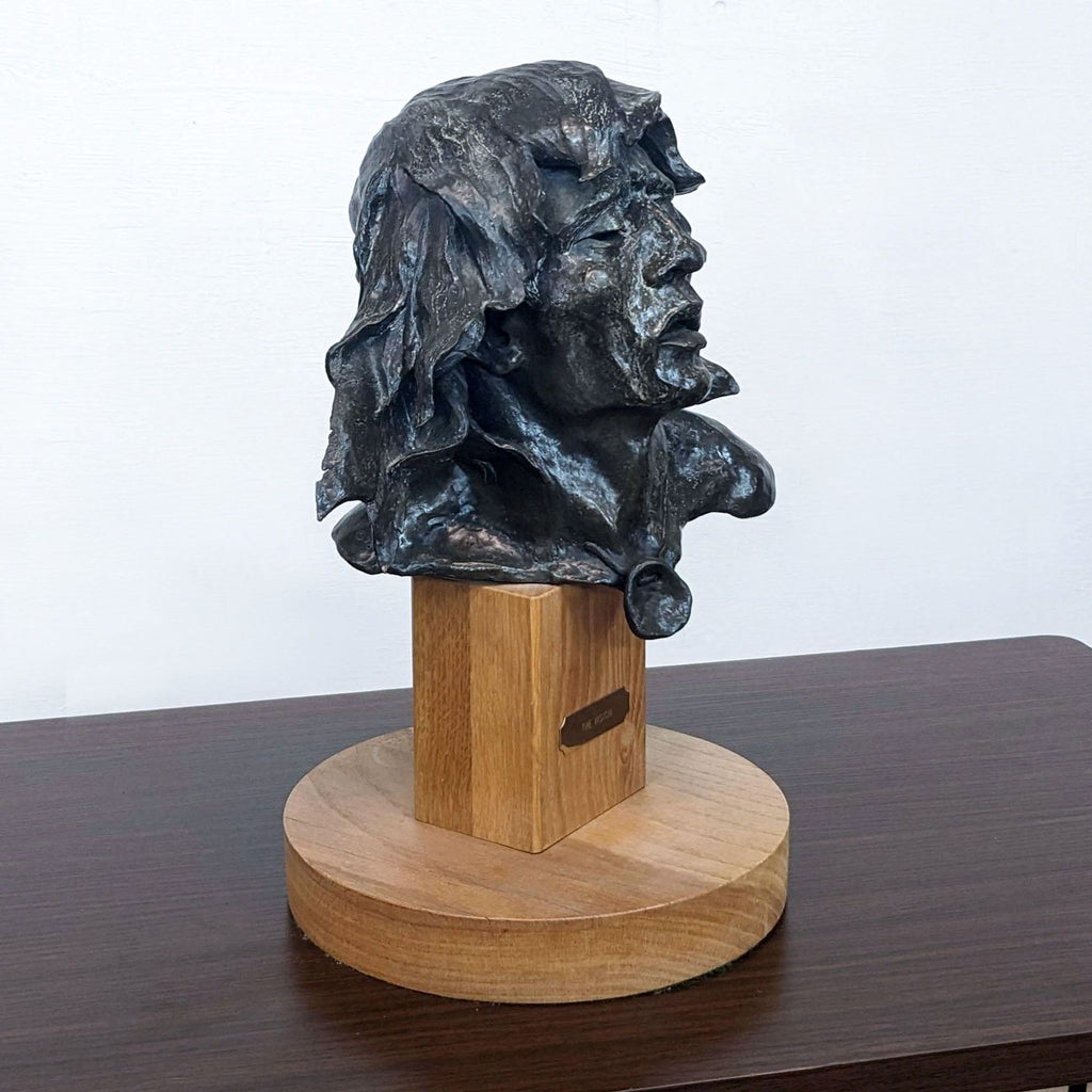 Angled view of Ron Herron's bronze sculpture "The Vision" on a polished wooden stand.