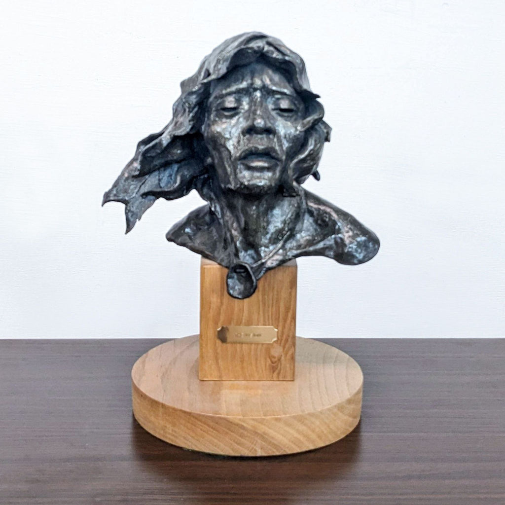 Bronze statue titled “The Vision” on a wooden base by Ron Herron.