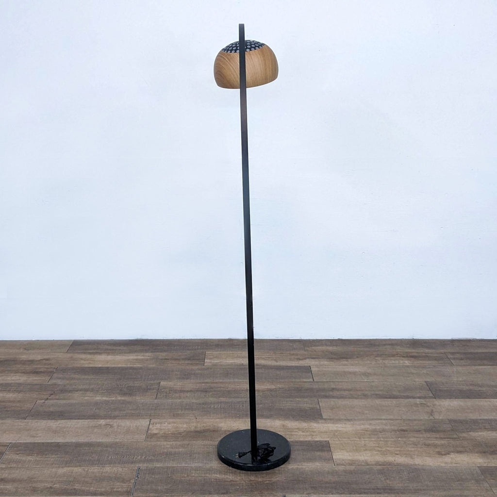 Modern floor lamp with curved design and a stable base, featuring a faux woodgrain shade.