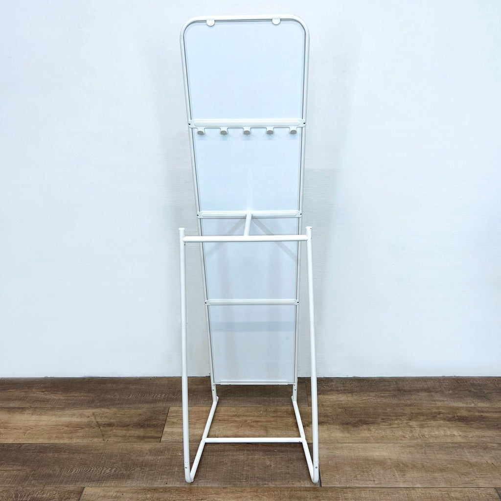 Ikea mirror with white metal stand, featuring hooks and a clothes rod.