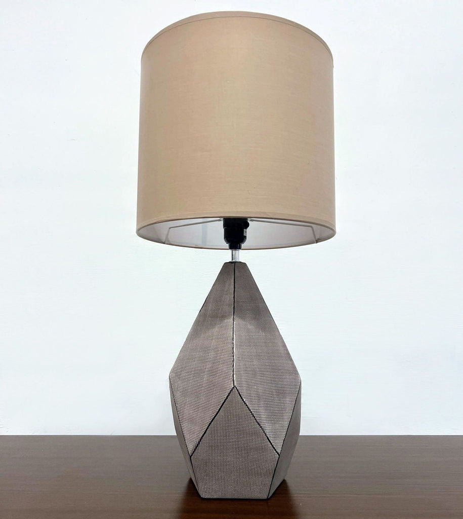 1. Reperch lamp with a geometric neutral textured base and cylindrical beige shade, standing on a wooden surface.  