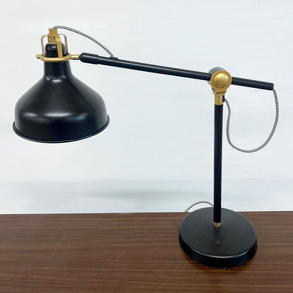 a vintage industrial desk lamp with a brass and black shade.
