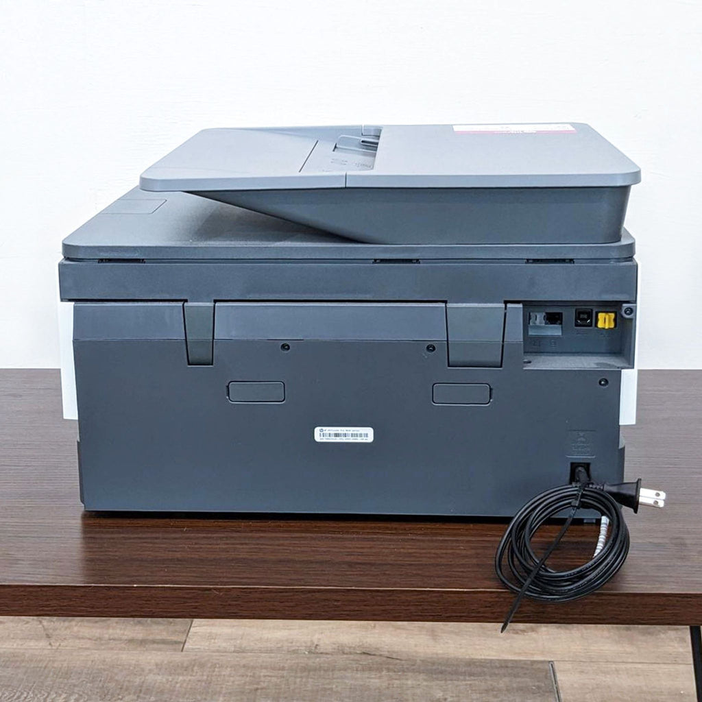 Rear view of HP printer showing back panel and power cord.