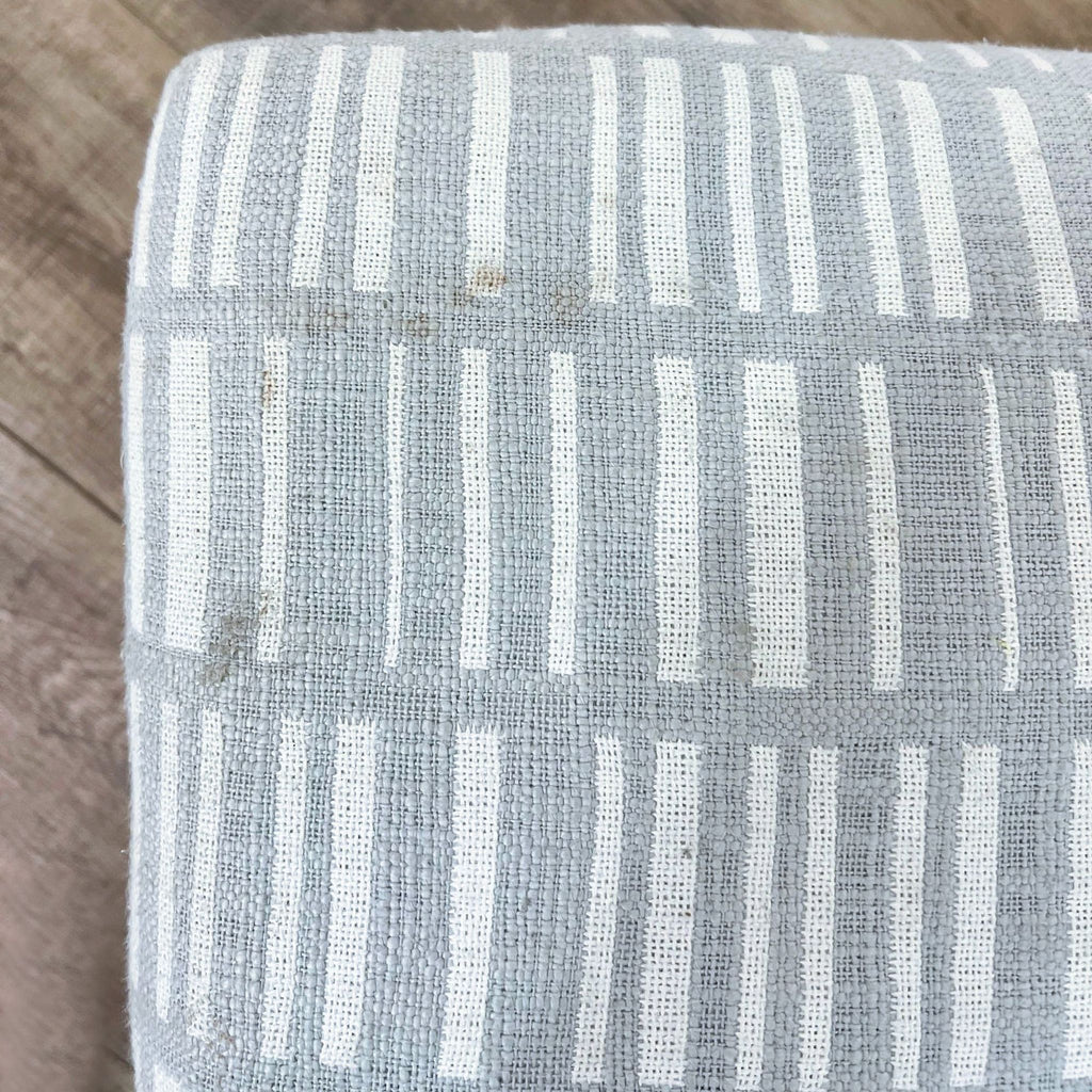 Close-up of gray striped fabric pattern on bench cushion.