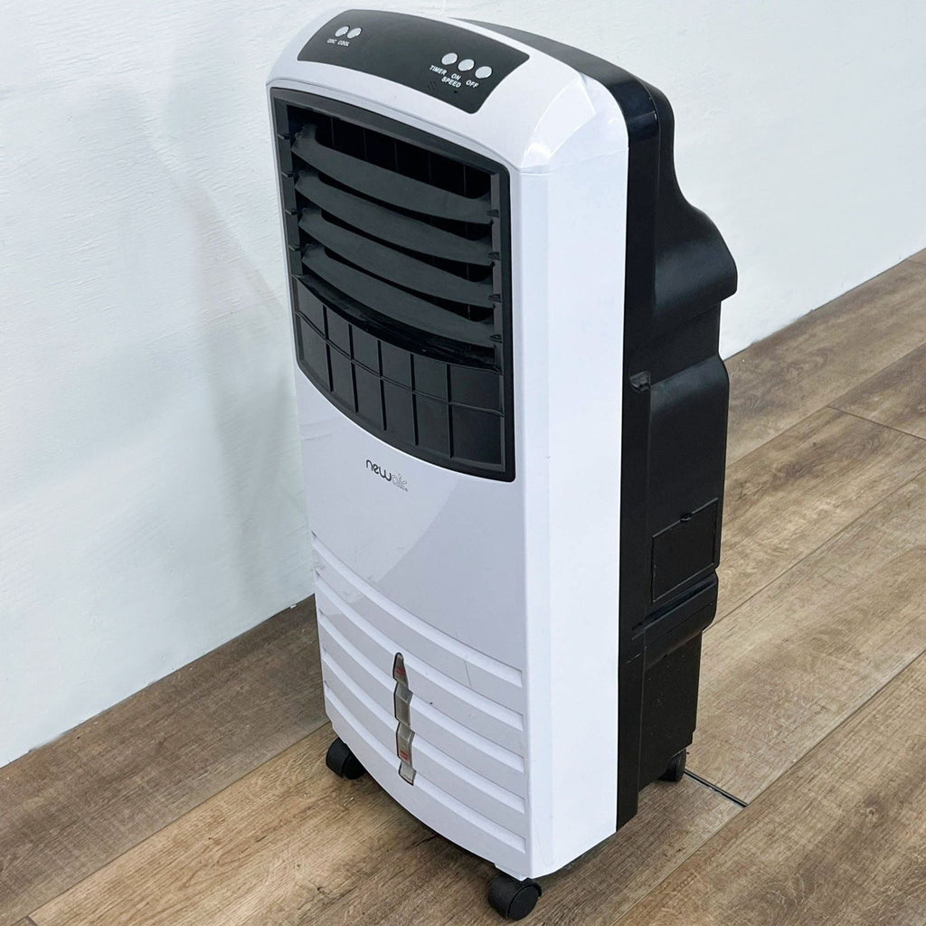 Angled side view of NewAir portable air cooler on a wooden floor.
