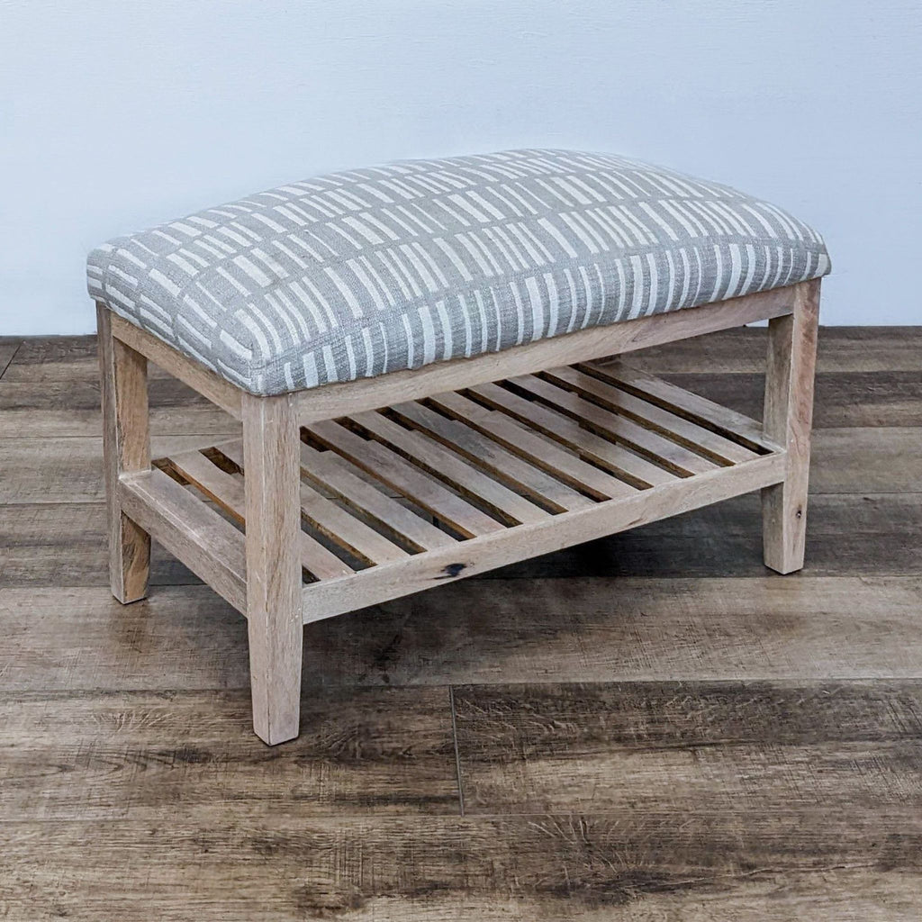Angle view of a gray-striped bench with wooden frame and lower shoe storage.