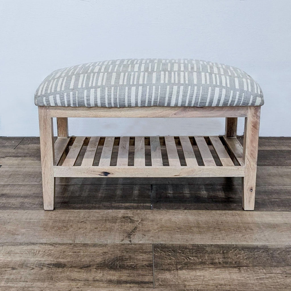 Gray bench with light wood frame and striped padded top, featuring a shoe shelf.