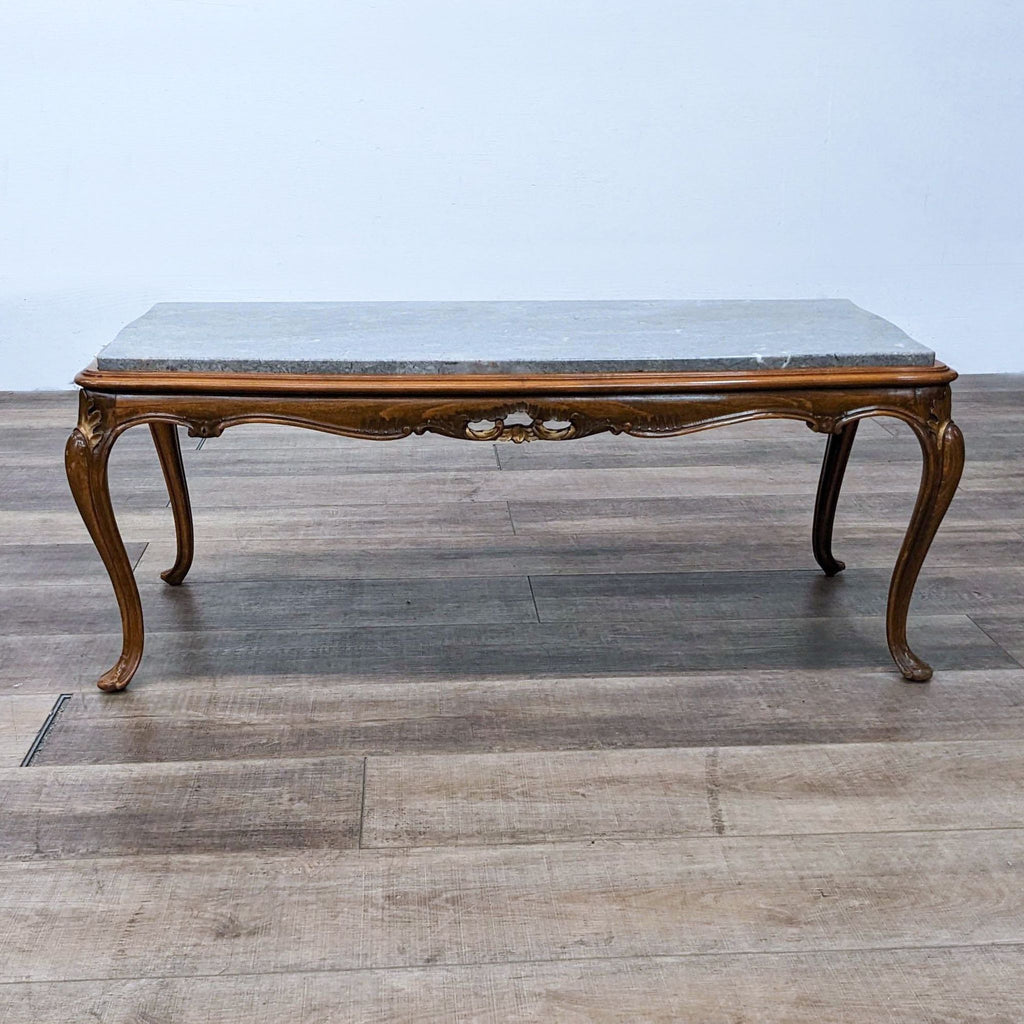 Carved coffee table with cabriole legs and a marble top.