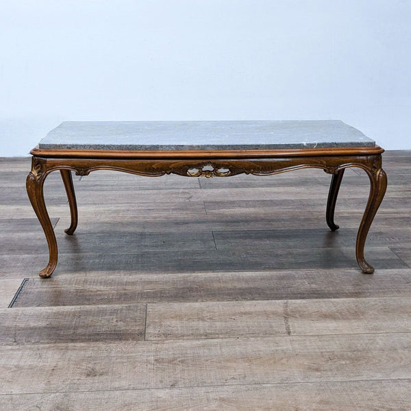 Carved coffee table with cabriole legs and a marble top.