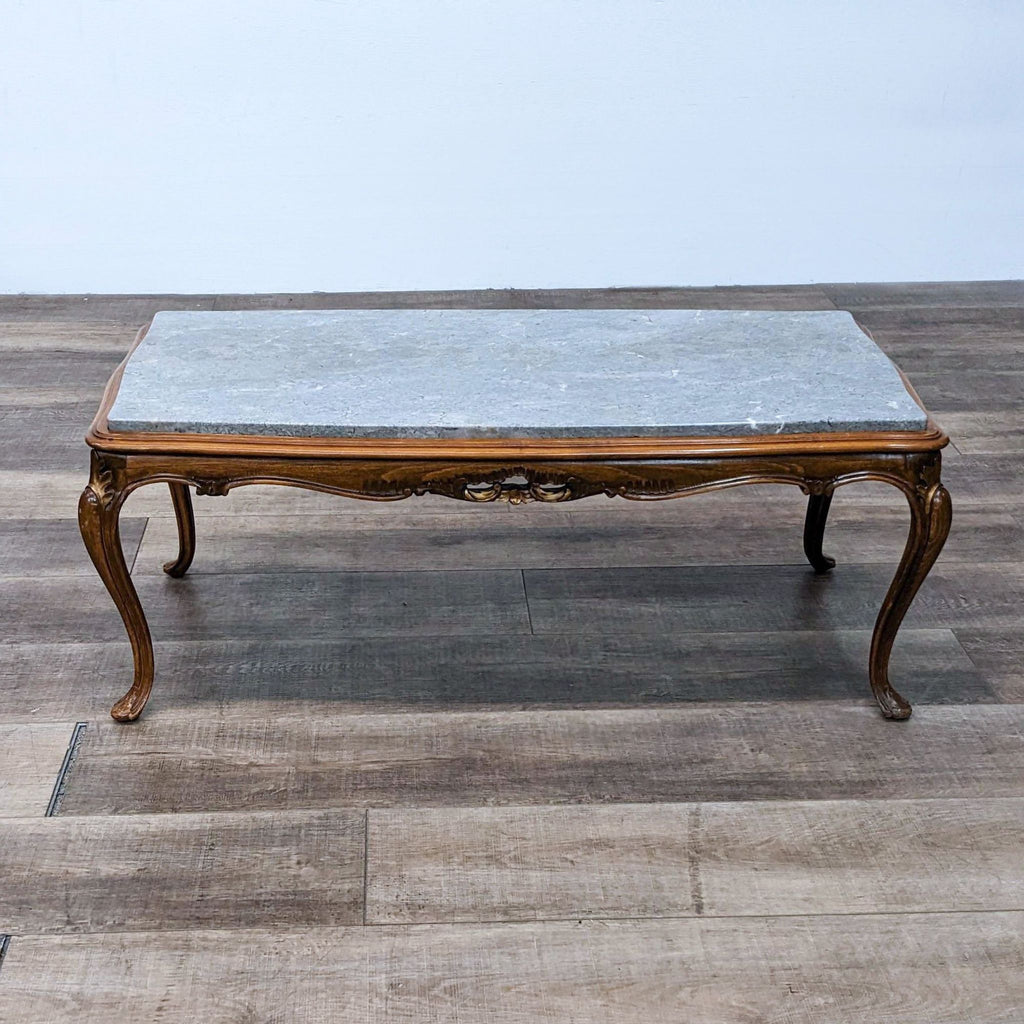 Reperch coffee table featuring a marble top and ornate legs.