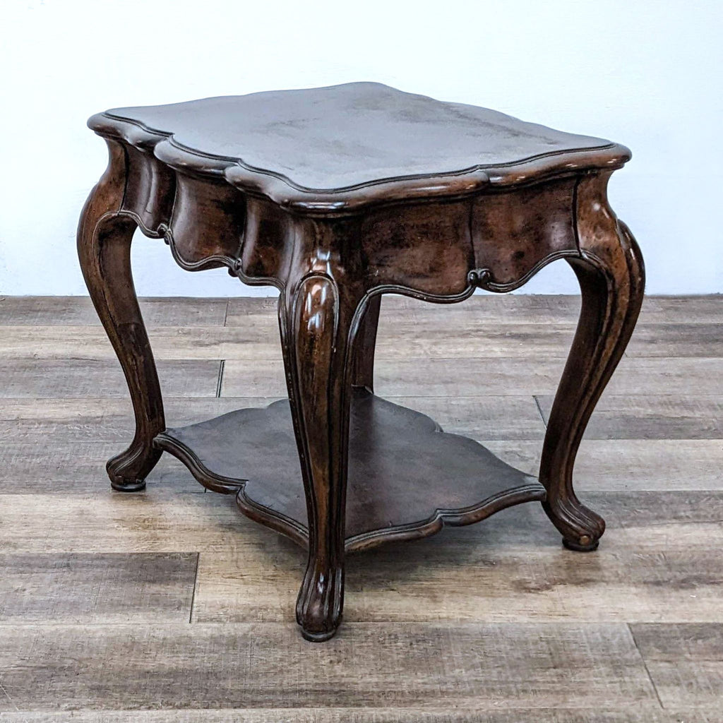 Side view of an ornate wooden table with curved legs and a storage shelf.