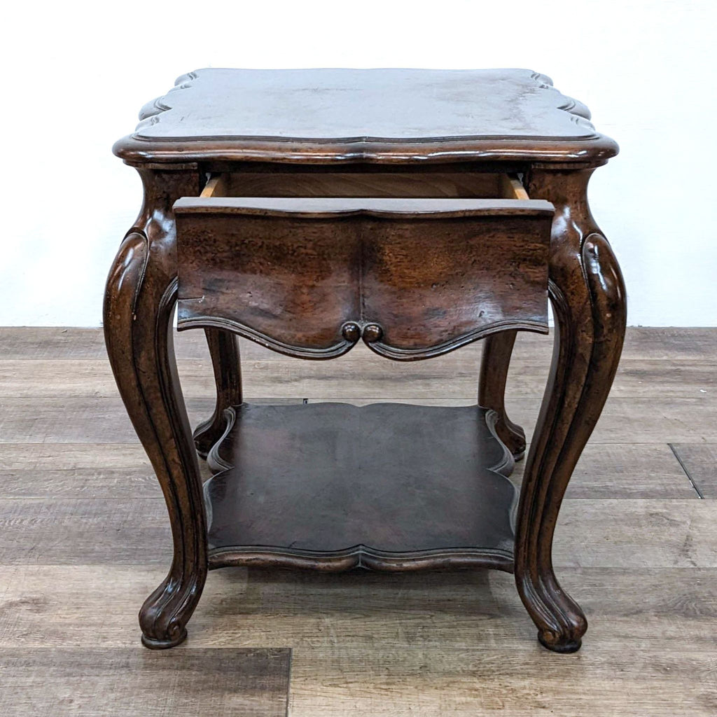 Serpentine table with inlaid top, cabriole legs, and a storage shelf.