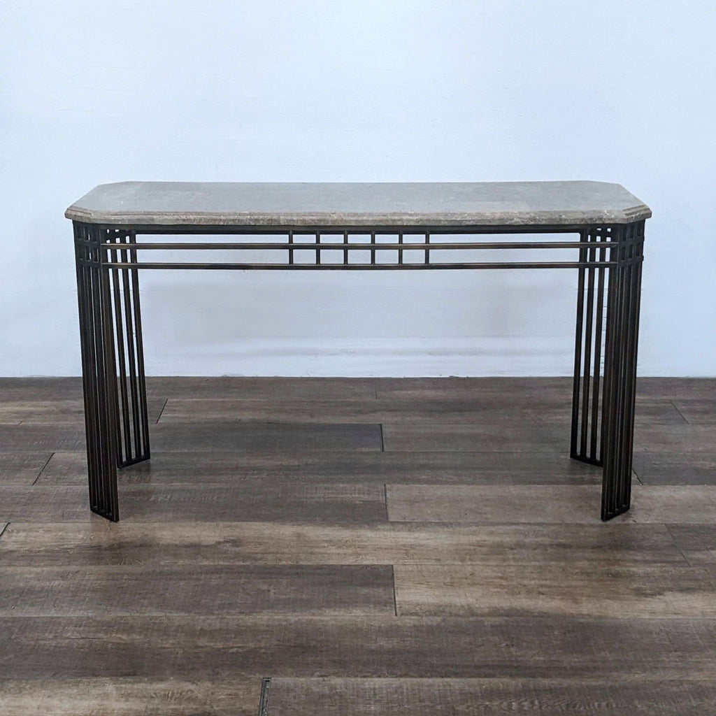 Reperch console table with a marble top and geometric metal frame.