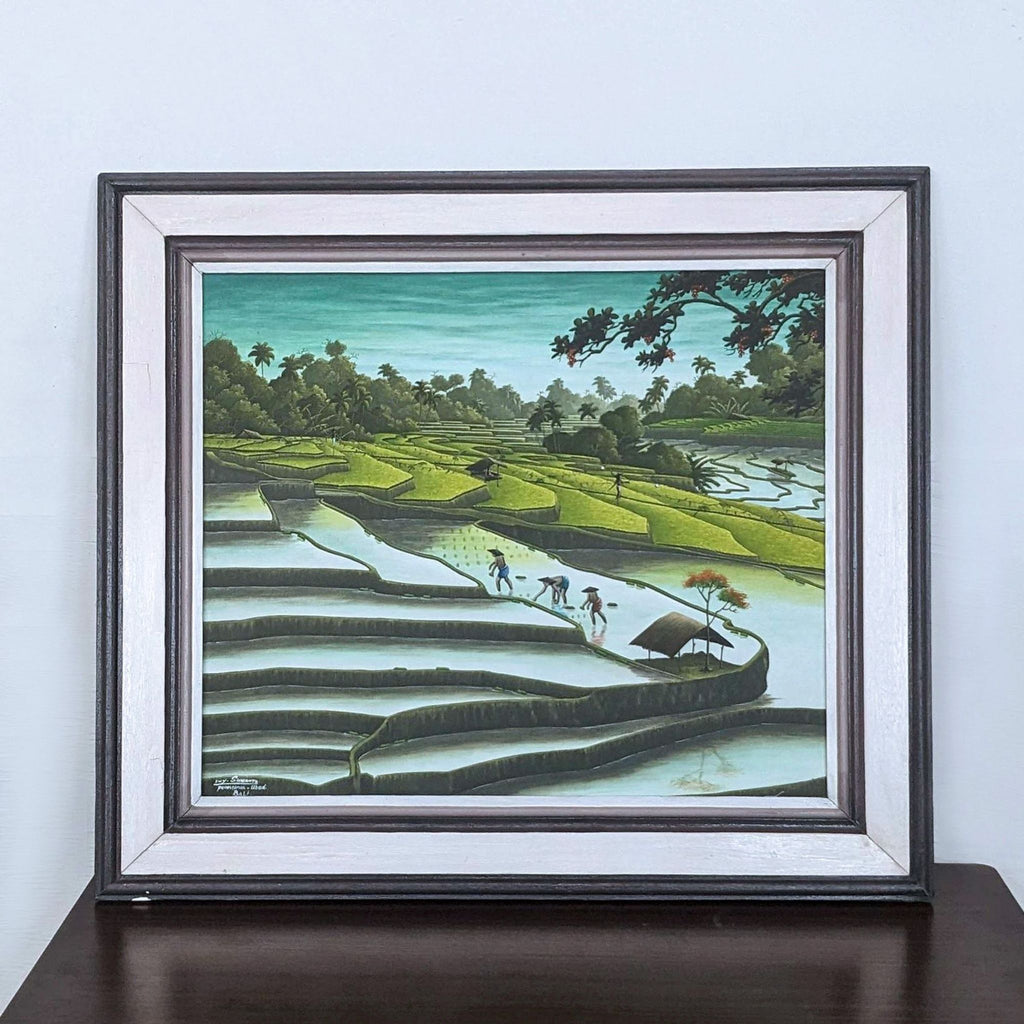 Framed painting of Bali rice fields with farmers and lush greenery.