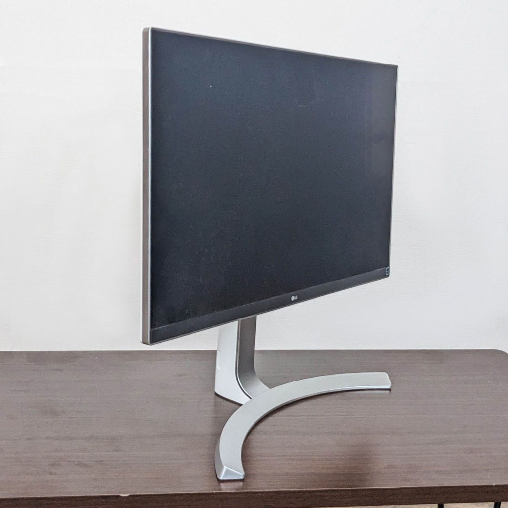 Side view of LG monitor showing sleek design and curved stand on a desk.