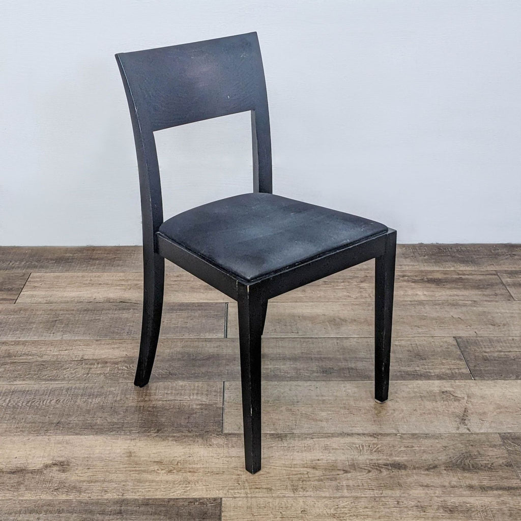 Single Reperch dining chair shown at an angle, highlighting the curved wood back and soft upholstered seat.