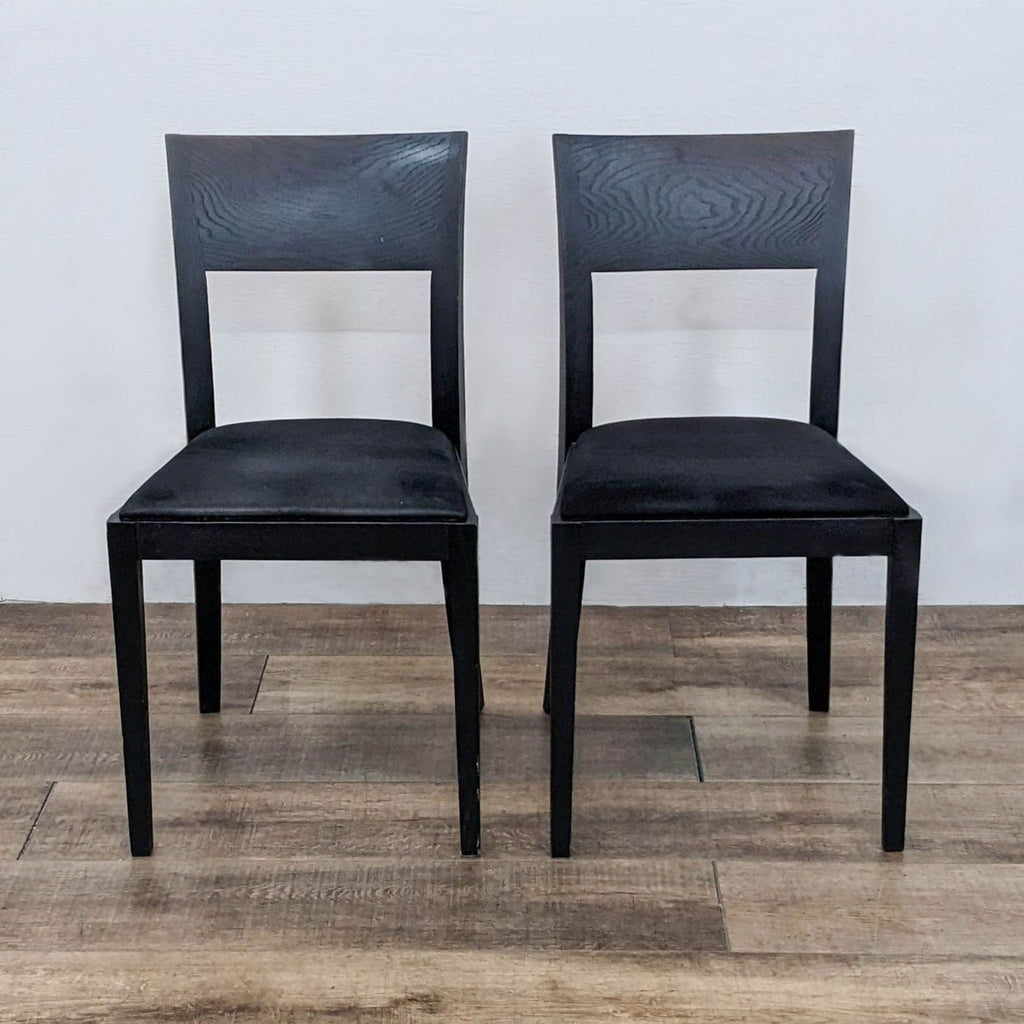 Pair of Reperch dining chairs with solid wood frames, curved backs, and upholstered black seats.