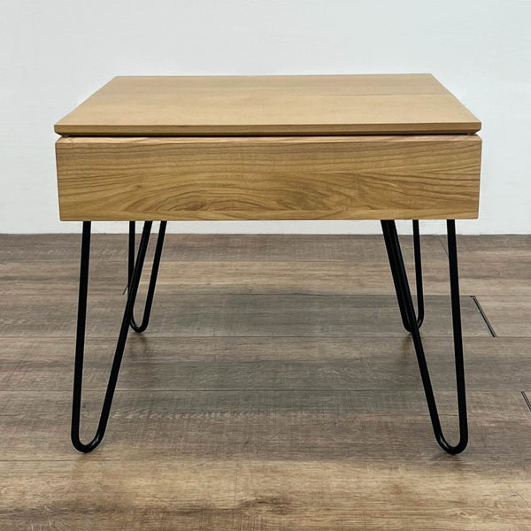 Square table with hairpin legs, wood finish, and removable lid for storage on wooden floor.