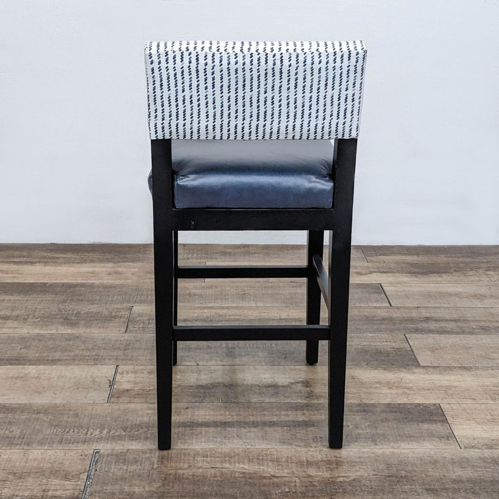 Rear view of stool showing navy seat, patterned back, and sturdy wooden legs.