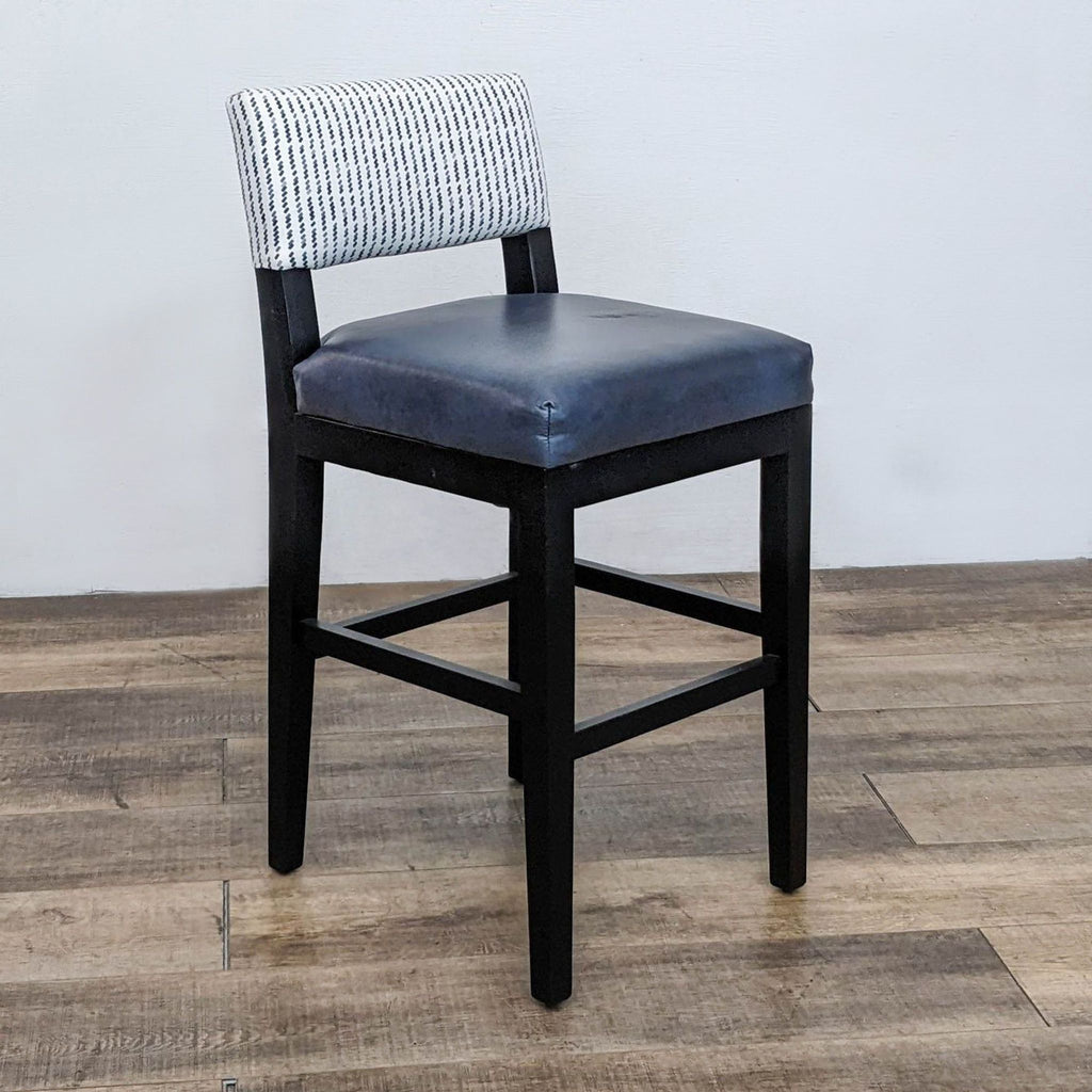 Patterned back stool with navy seat and dark wood frame on a wooden floor.