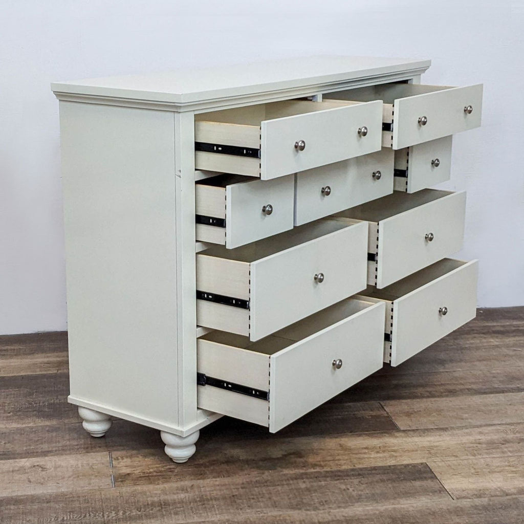 2. Angled view of Aspen Home Cambridge “Chesser” dresser showing all 9 drawers open on extension glides.  
