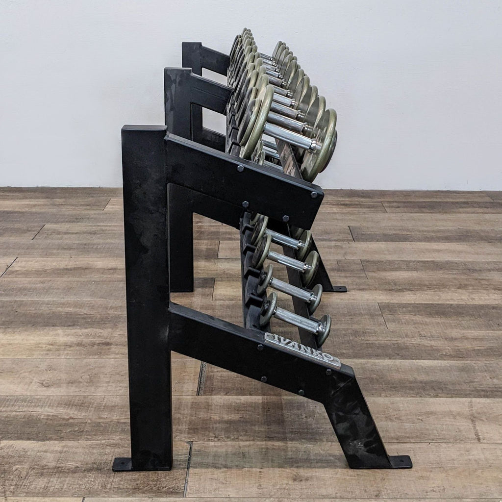 Side view of Ivanko dumbbells on a black knock-down rack on wooden floor.