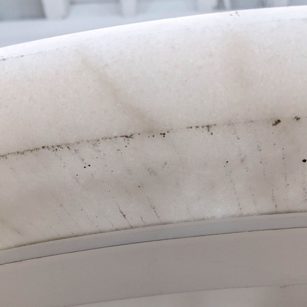 Detailed edge view of the round white marble top with subtle surface markings.