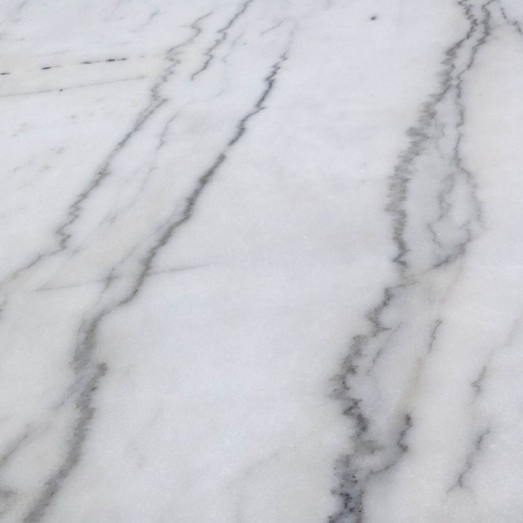 Close-up of the white marble tabletop with distinct gray veining pattern from dining table.