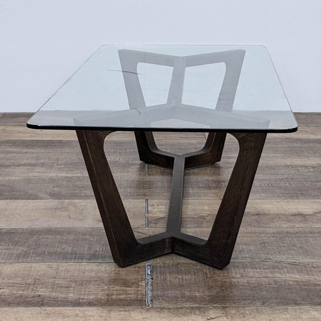 Glass top coffee table featuring a modern wooden trestle design, Square Roots Furniture.