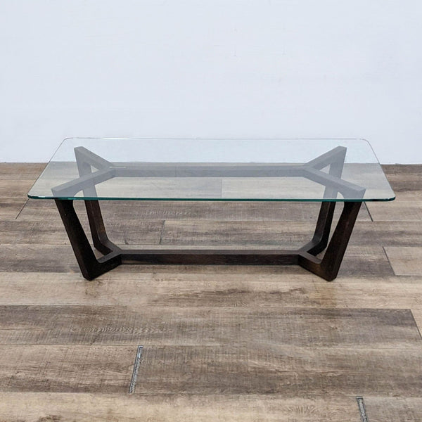 Square glass coffee table with a dark wood trestle base from Square Roots Furniture.