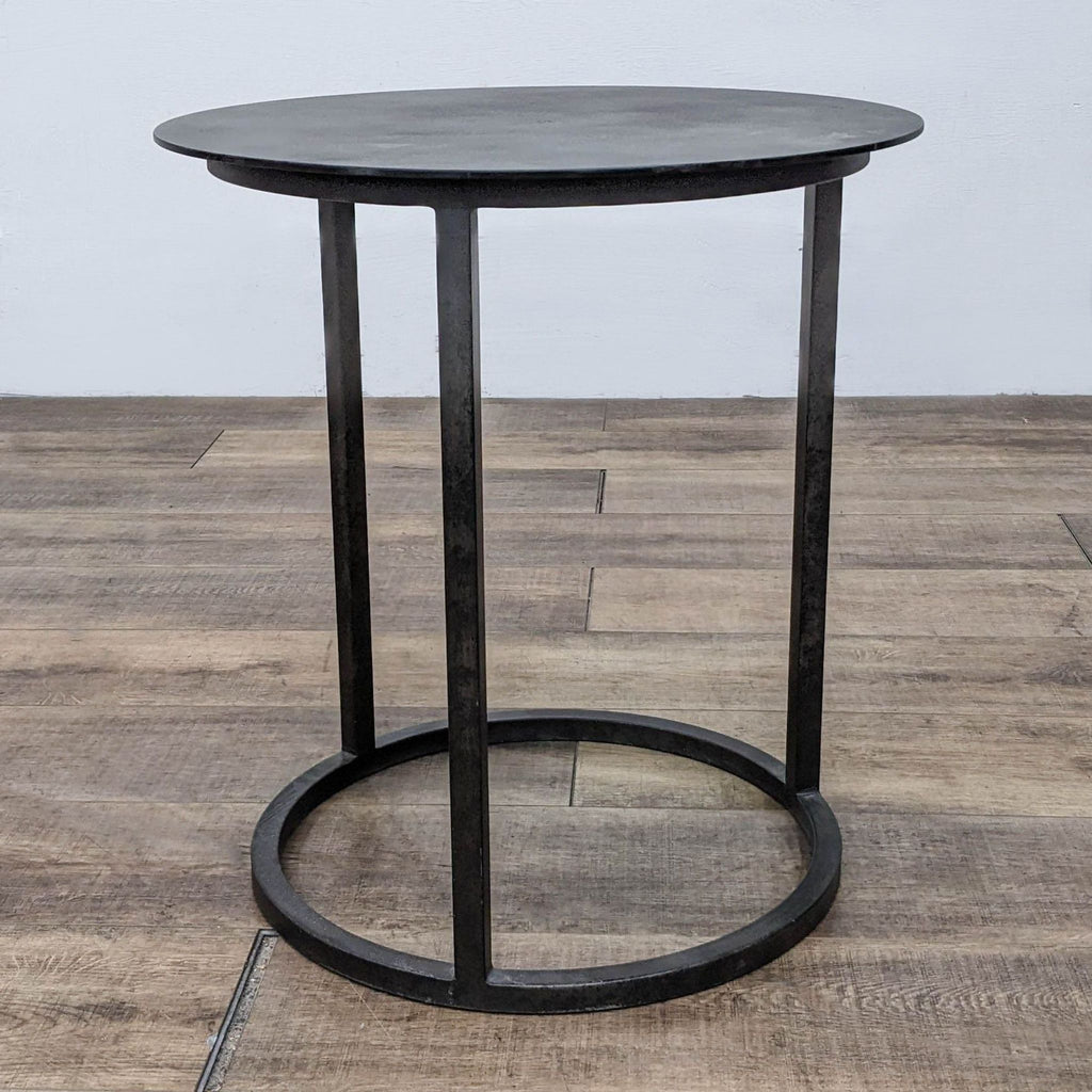 Restoration Hardware black metal side table with round top and base.